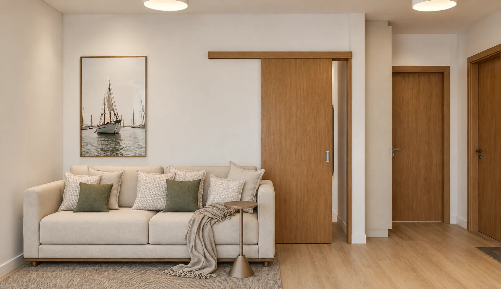 Render da sala de estar do apartamento: sofá claro com almofadas verdes, quadro de veleiro, porta de correr de madeira e piso de madeira